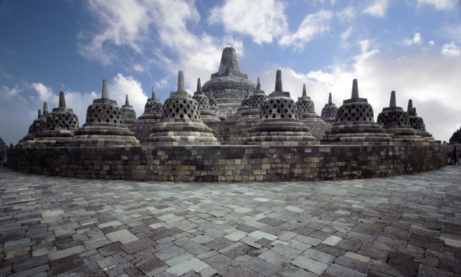 Stupa-stupa di pelataran atas Candi Borobudur di bawah langit biru berawan